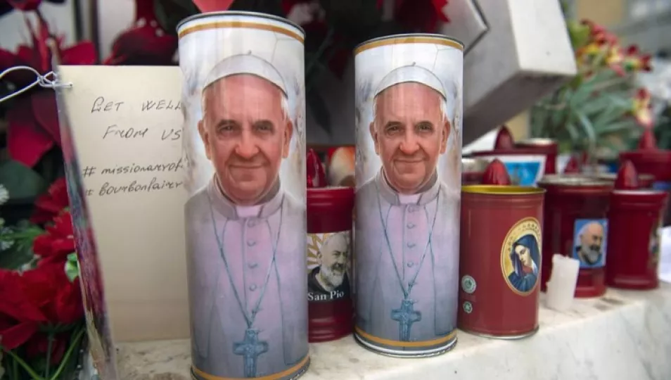 Velas con la foto del Papa Francisco colocadas al frente de la clínica donde se encuentra hospitalizado