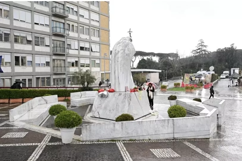 Continúan rezos de los fieles frente a una estatua del Papa Juan Pablo II en el exterior del hospital Agostino Gemelli.