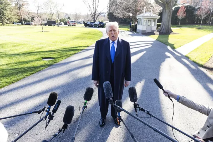 Donald Trump preparándose para hablar con los medios de comunicación mientras sale de la Casa Blanca.
