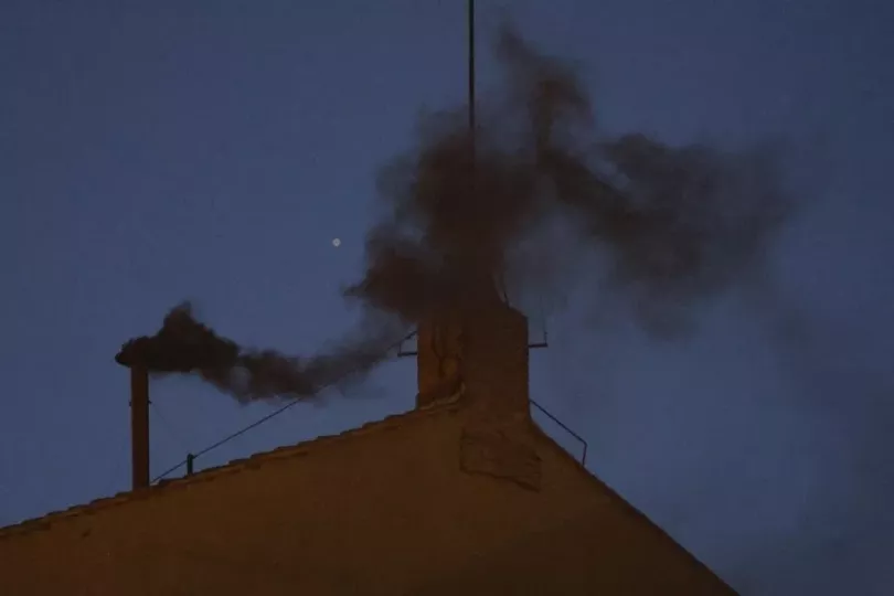 El humo negro saliendo de la chimenea en el techo de la Capilla Sixtina en el primer día del cónclave para elegir un nuevo Papa en la Ciudad del Vaticano.