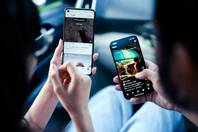 Dos usuarios de Instagram utilizando la red social en sus móviles.