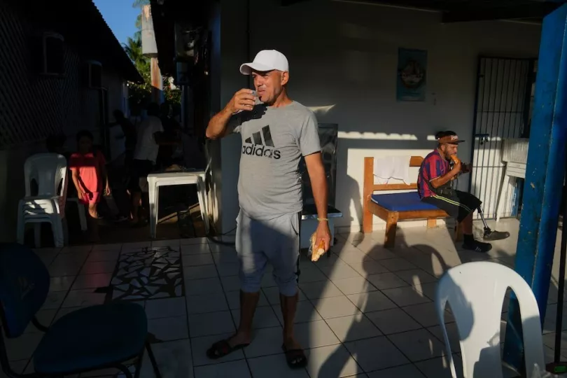 Miguel Hidalgo, un migrante cubano, toma un vaso de leche para desayunar en un albergue en Rio Branco, Brasil 