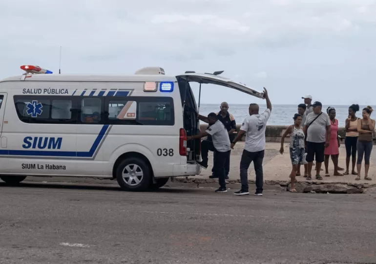 Operativo de los bomberos y servicios de emergencia rescatando a una persona del mar en el Malecón de La Habana.