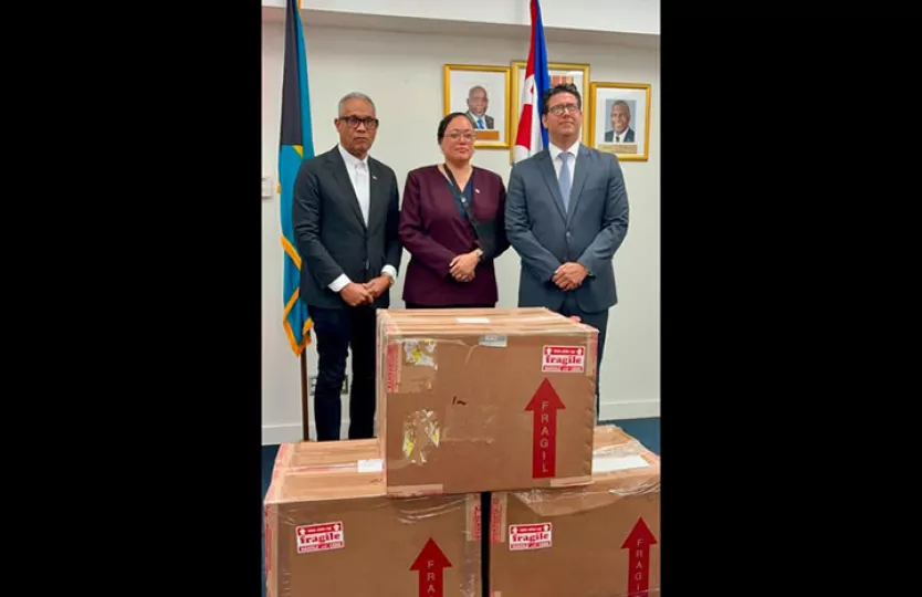 Autoridades de Bahamas y representantes diplomáticos de Cuba durante la entrega del primer donativo de medicamentos para pacientes oncológicos pediátricos en el Aeropuerto Internacional Lynden Pindling.