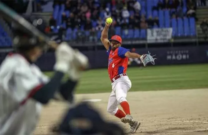 Jugadores de sóftbol en un terreno de juego durante un torneo internacional.