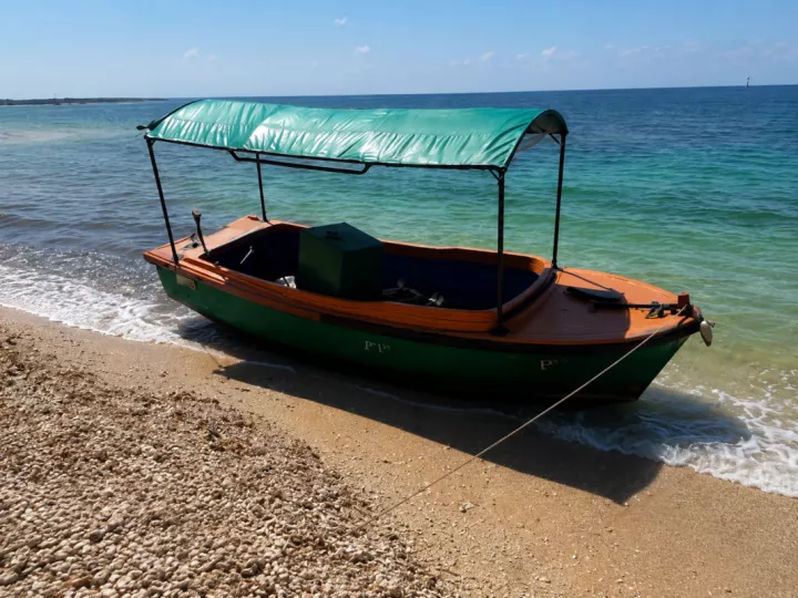Embarcación de madera precaria llegando a las costas de Key West con migrantes a bordo.