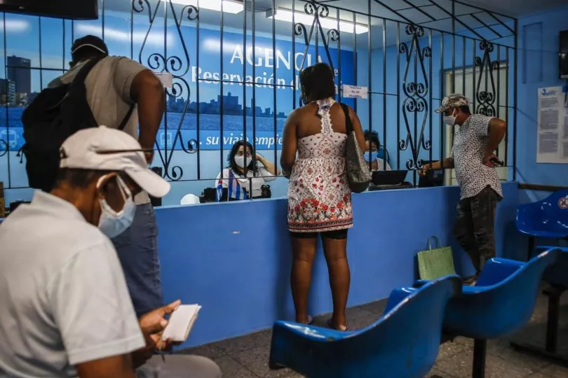 Pasajeros en una terminal ferroviaria de Cuba esperando información sobre sus viajes.