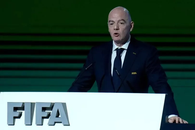 Gianni Infantino durante una conferencia de prensa de la FIFA rodeado de banderas.