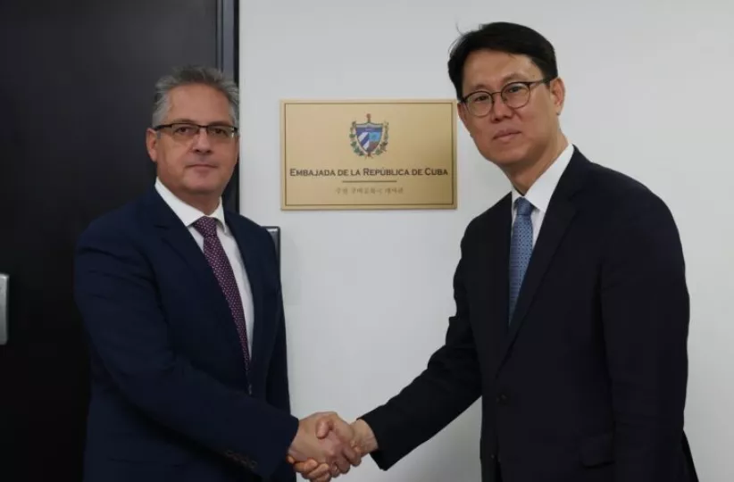 Representantes de los ministerios de Exteriores de Cuba y Corea del Sur se saludan. 