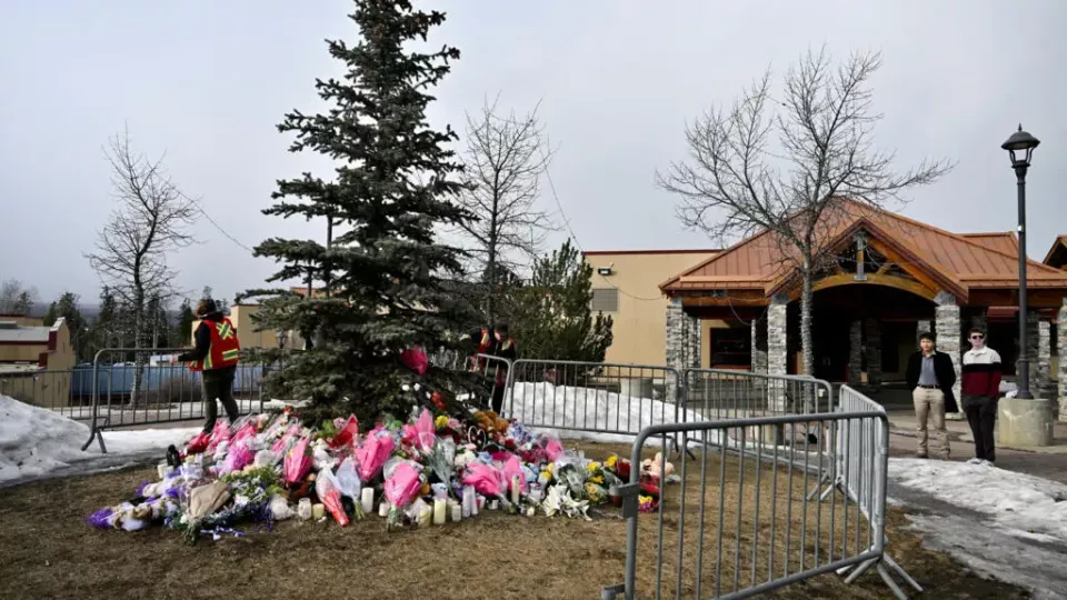 unos trabajadores instalan una valla alrededor de un memorial improvisado en honor a las víctimas, dos días después de que se produjera un tiroteo masivo mortal en una escuela de la localidad de Tumbler Ridge, Columbia Británica (Canadá), el 12 de febrero de 2026