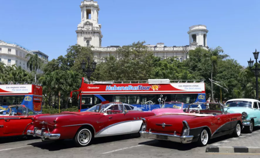 Autos clásicos y un ómnibus aguardan por turistas en las calles de La Habana.