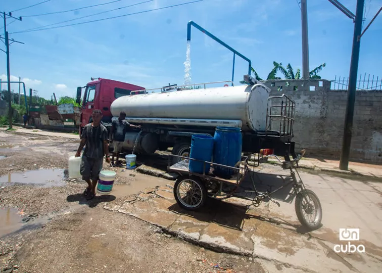 Una pipa de agua y personas recolectando agua en La Habana durante la crisis de suministro.