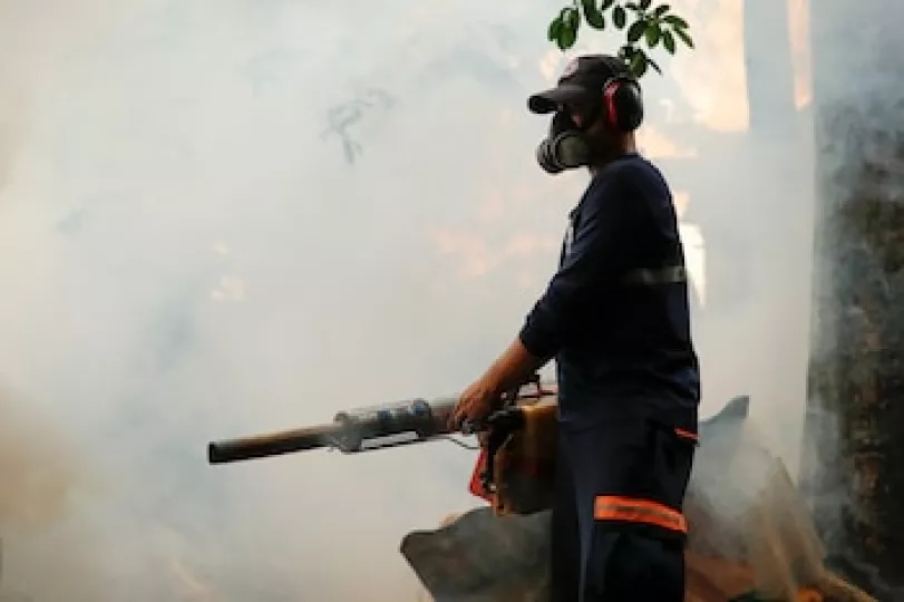 Personal sanitario realizando labores de fumigación en calles de Cuba como medida preventiva contra el mosquito Aedes aegypti.