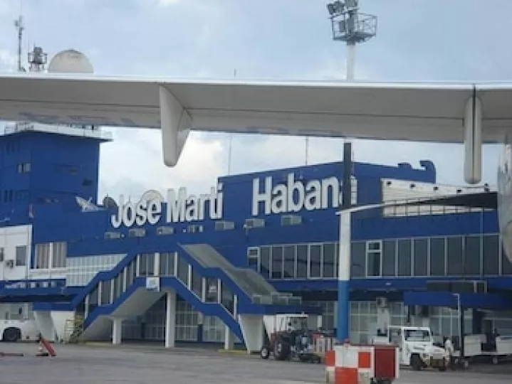 Vista exterior de una torre de control y pista de aterrizaje en un aeropuerto cubano.