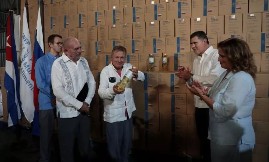 Autoridades cubanas y representantes rusos durante la recepción oficial de un cargamento de aceite vegetal como parte de una donación humanitaria.