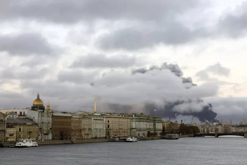 Vista nocturna con humo saliendo de instalaciones industriales tras un ataque de drones en Rusia.