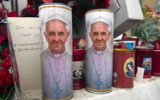Velas con la foto del Papa Francisco colocadas al frente de la clínica donde se encuentra hospitalizado