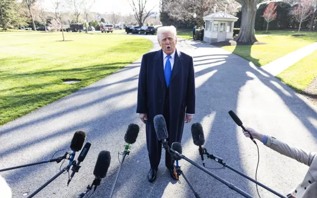 Donald Trump preparándose para hablar con los medios de comunicación mientras sale de la Casa Blanca.