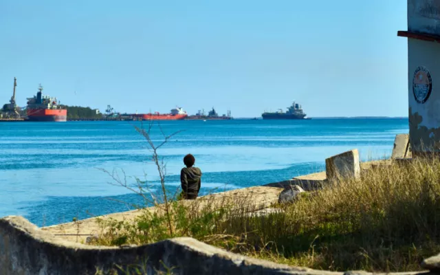 Una persona observa un barco de combustibles en la bahía de Matanzas. Foto: EFE/STR.