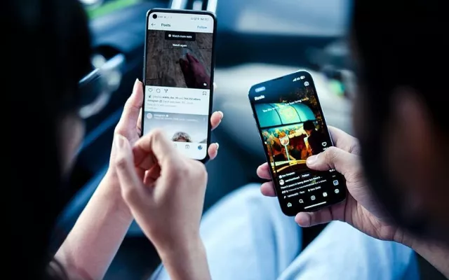 Dos usuarios de Instagram utilizando la red social en sus móviles.