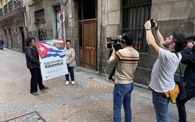 Dos personas portan el cartel de la campaña 'Argia eta indarra Kubarentzat. ¡Contra el bloqueo, energía para Cuba!'