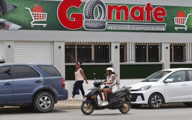 Personas pasan frente al local comercial Gomate en La Habana (Cuba).
