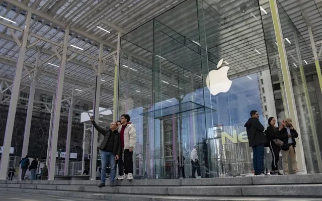 Multitud de personas tomando fotografías en la entrada de la icónica tienda de Apple en la Quinta Avenida de Nueva York.