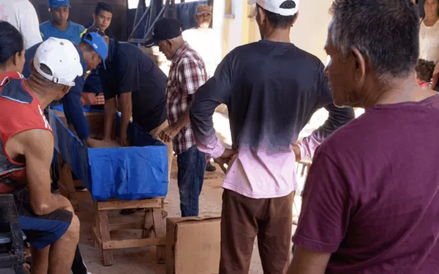 Familiares y vecinos en Cuba armando de forma rudimentaria un ataúd utilizando pedazos de cartón.