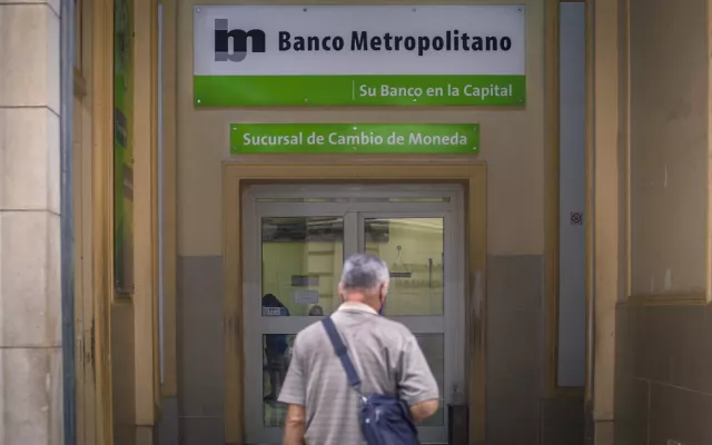Edificio de banco en Cuba con personas en el exterior.