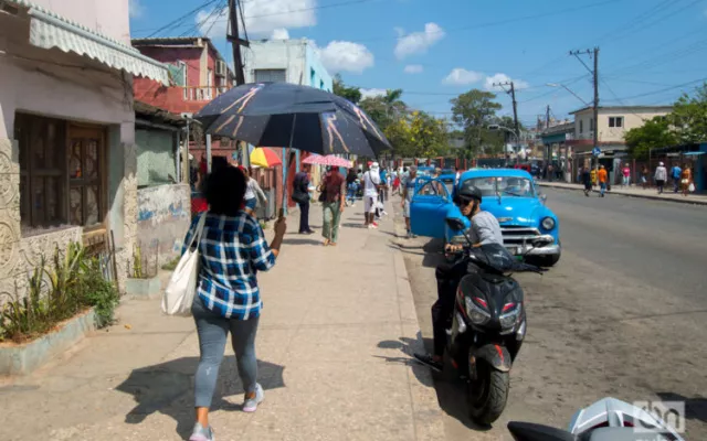 Una mujer se protege del sol con una sombrilla en La Habana.