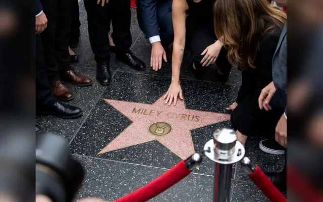 Miley Cyrus posando junto a su nueva estrella en el Paseo de la Fama de Hollywood rodeada de sus allegados.