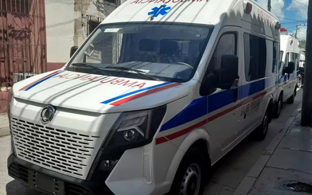 Una fila de nuevas ambulancias de color blanco y azul estacionadas al aire libre.
