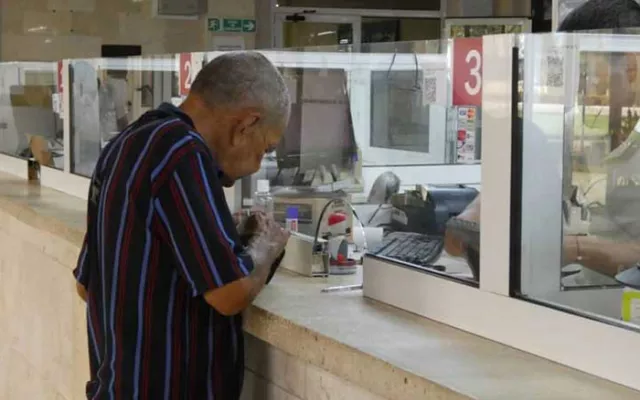 Imagen de jubilados cubanos utilizando una tarjeta magnética en un cajero automático.