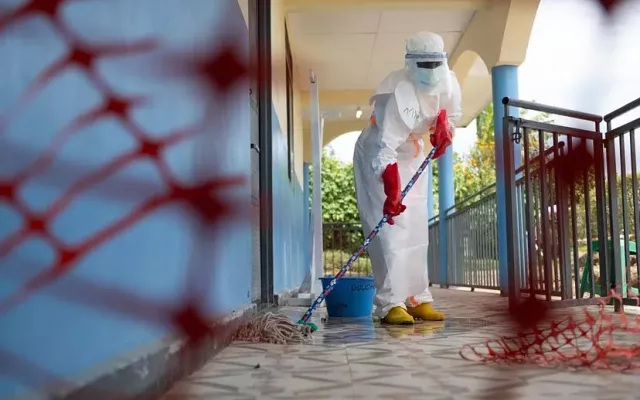 Un trabajador realiza tareas de limpieza en una de las zonas afectadas por el brote de ébola en África