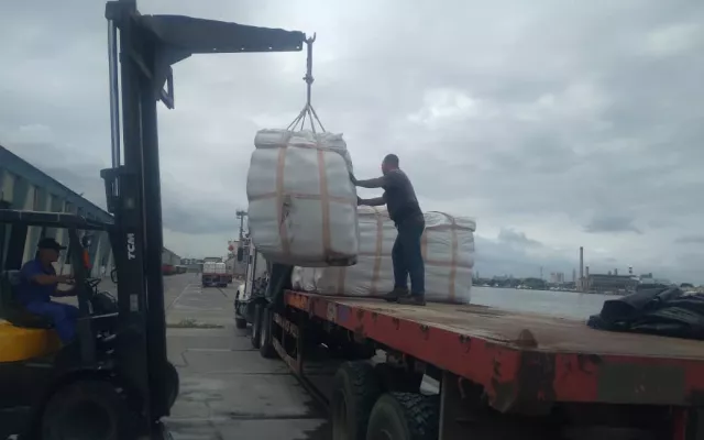 Sacos de cemento apilados en un almacén portuario.