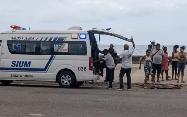 Operativo de los bomberos y servicios de emergencia rescatando a una persona del mar en el Malecón de La Habana.