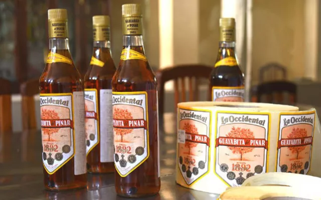 Botellas de licor Guayabita del Pinar exhibidas en una mesa, resaltando el producto tradicional cubano.