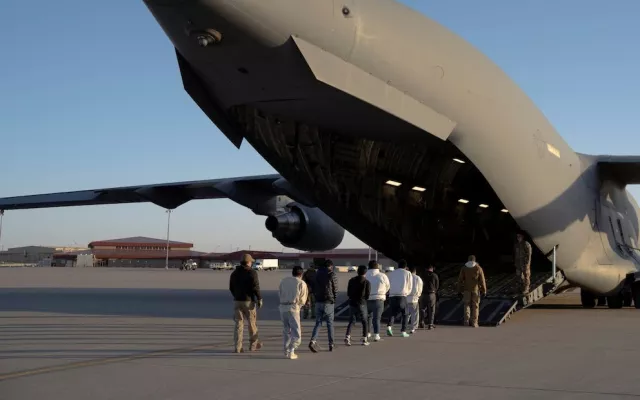 Agentes de seguridad del Servicio de Aduanas y Protección Fronteriza de EE. UU. guían a migrantes detenidos para abordar un avión C-17 Globemaster III de la Fuerza Aérea de EE. UU. para un vuelo de deportación en Fort Bliss, Texas, EE. UU., el 23 de enero de 2025. Departamento de Defensa/Sargento de primera clase del Ejército de EE. UU