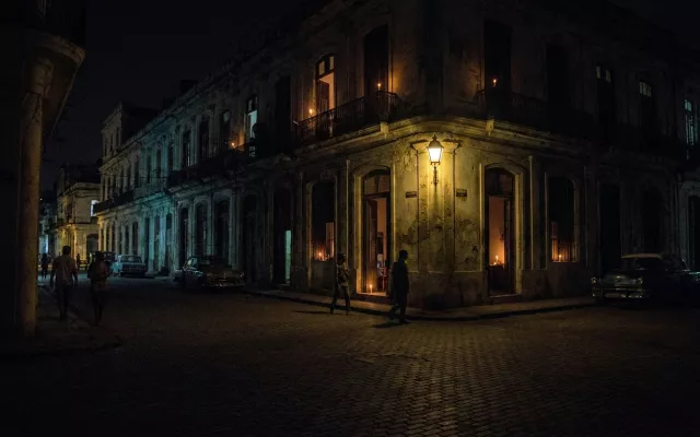 Vista nocturna de una calle en La Habana con iluminación precaria debido a la crisis energética.
