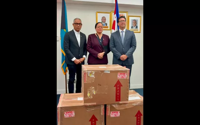 Autoridades de Bahamas y representantes diplomáticos de Cuba durante la entrega del primer donativo de medicamentos para pacientes oncológicos pediátricos en el Aeropuerto Internacional Lynden Pindling.