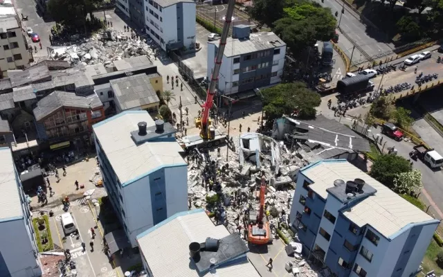 Bandera de Colombia a media asta frente a un edificio público en señal de luto nacional.