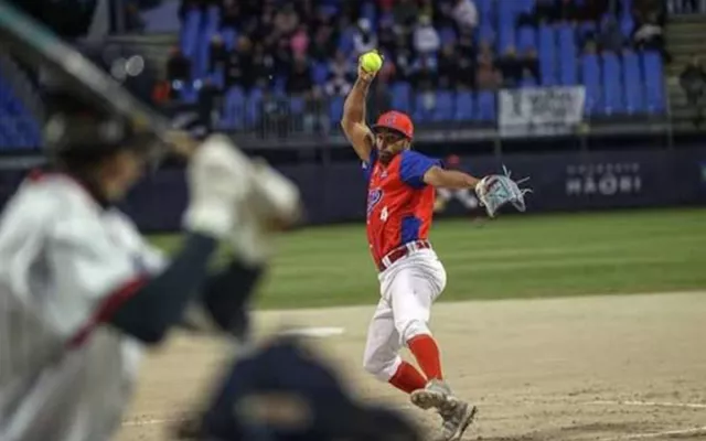 Jugadores de sóftbol en un terreno de juego durante un torneo internacional.