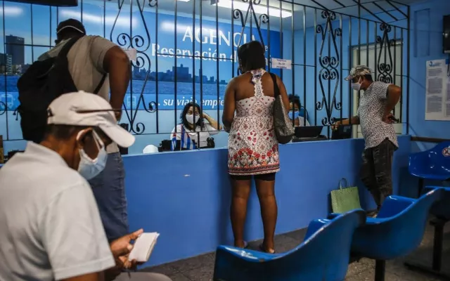 Pasajeros en una terminal ferroviaria de Cuba esperando información sobre sus viajes.
