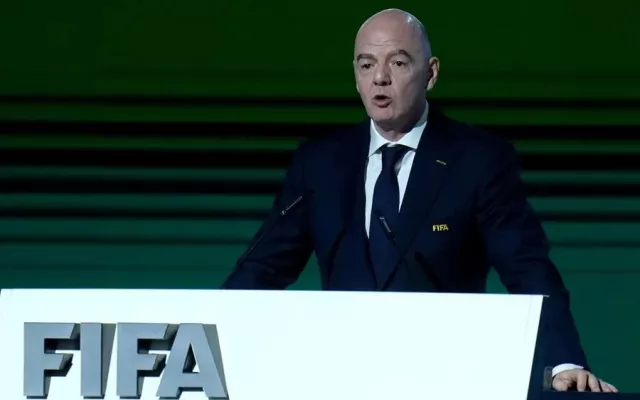 Gianni Infantino durante una conferencia de prensa de la FIFA rodeado de banderas.