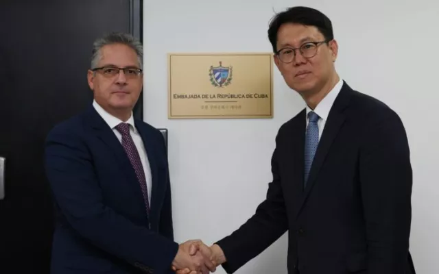 Representantes de los ministerios de Exteriores de Cuba y Corea del Sur se saludan. 