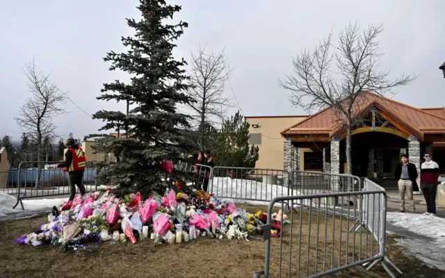 unos trabajadores instalan una valla alrededor de un memorial improvisado en honor a las víctimas, dos días después de que se produjera un tiroteo masivo mortal en una escuela de la localidad de Tumbler Ridge, Columbia Británica (Canadá), el 12 de febrero de 2026