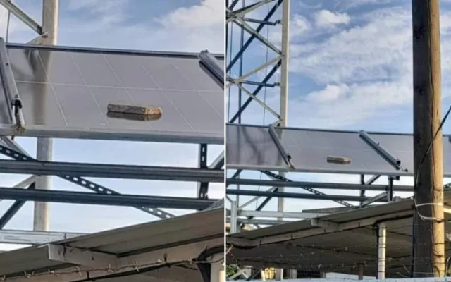 Paneles solares instalados en una estructura metálica con daños visibles por pedradas en Santiago de Cuba.