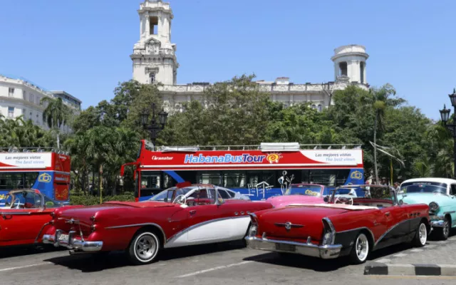 Autos clásicos y un ómnibus aguardan por turistas en las calles de La Habana.