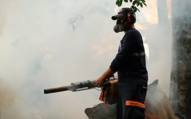 Personal sanitario realizando labores de fumigación en calles de Cuba como medida preventiva contra el mosquito Aedes aegypti.