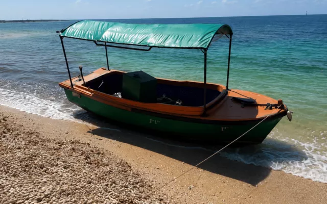Embarcación de madera con casco verde utilizada por migrantes cubanos para llegar a las costas de Florida.
